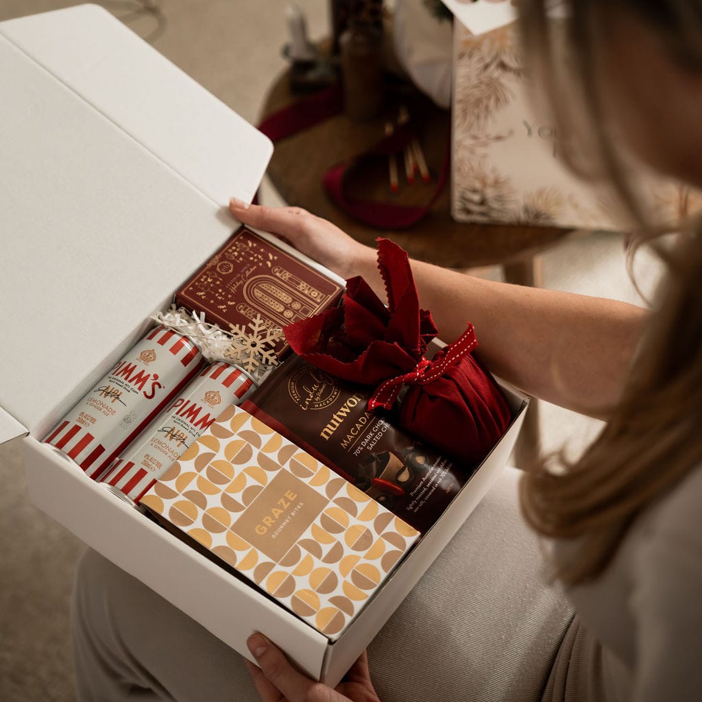 woman holding open gift box with contents showing