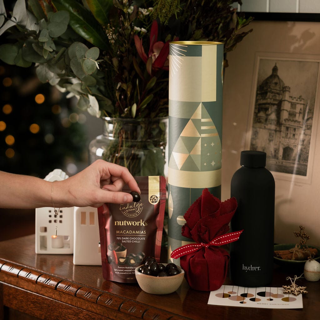 woman reaching for chocolate in christmas cylinder gift 