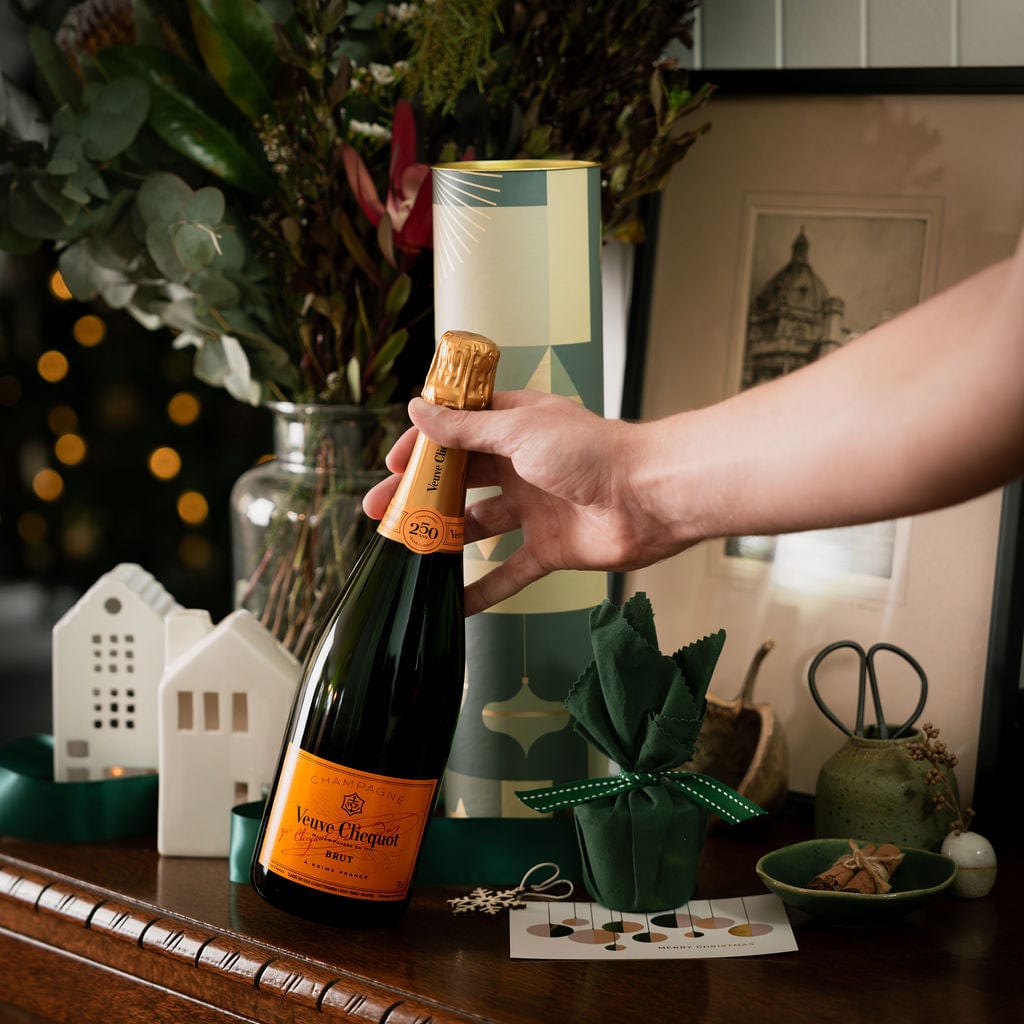 arm reaching for veuve on display as part of cylinder gift