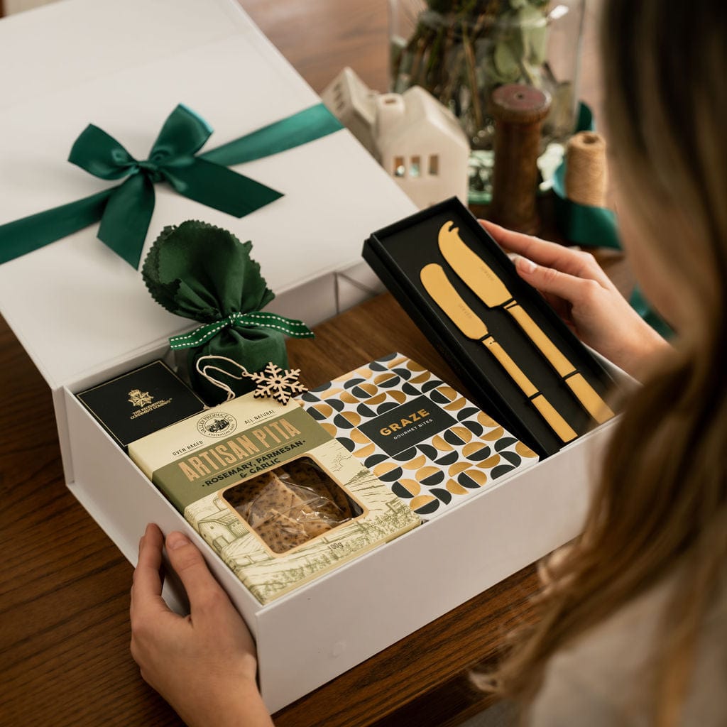 woman holding gold knife set as part of gift box 