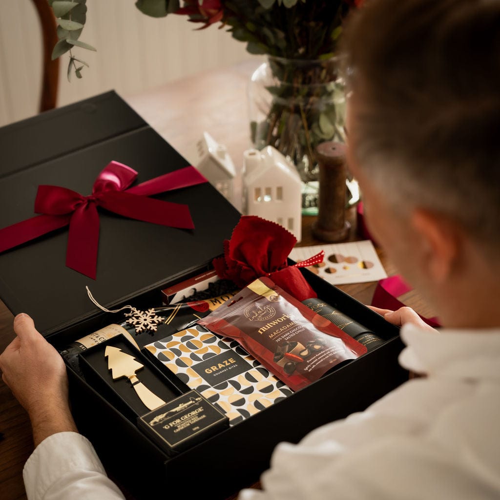 man holding open gift box to show contents