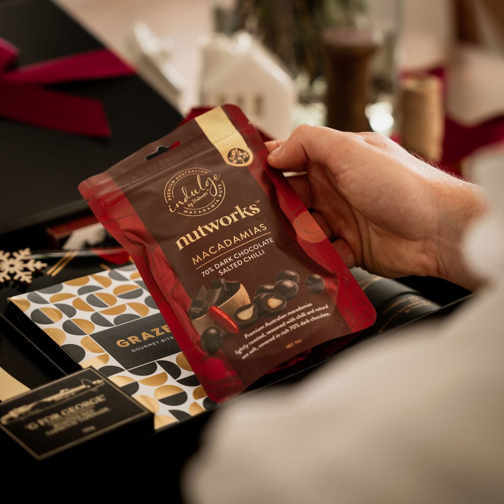 man holding chocolate covered macadamias as part of christmas gift box