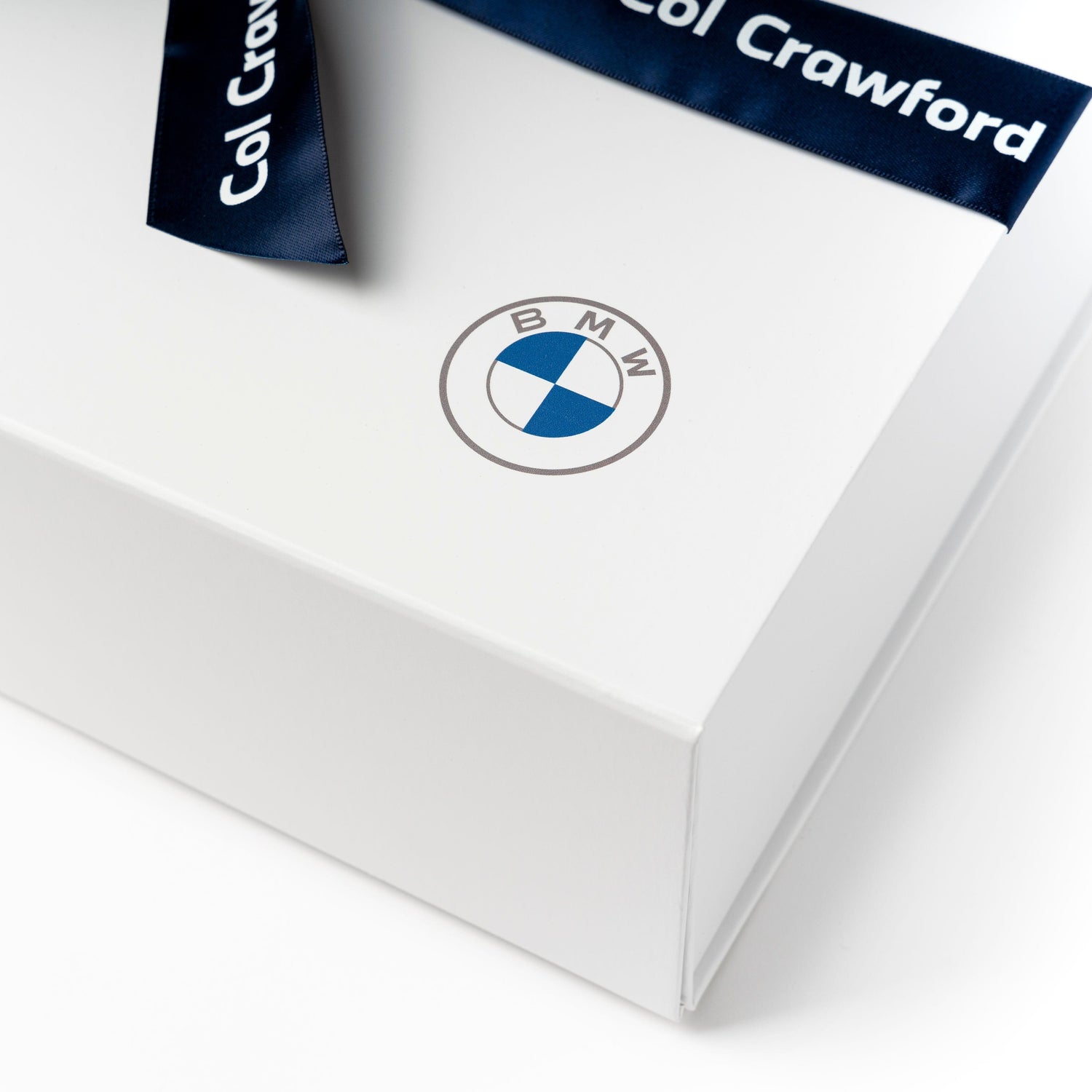 White gift box with logo branding and custom ribbon. 
