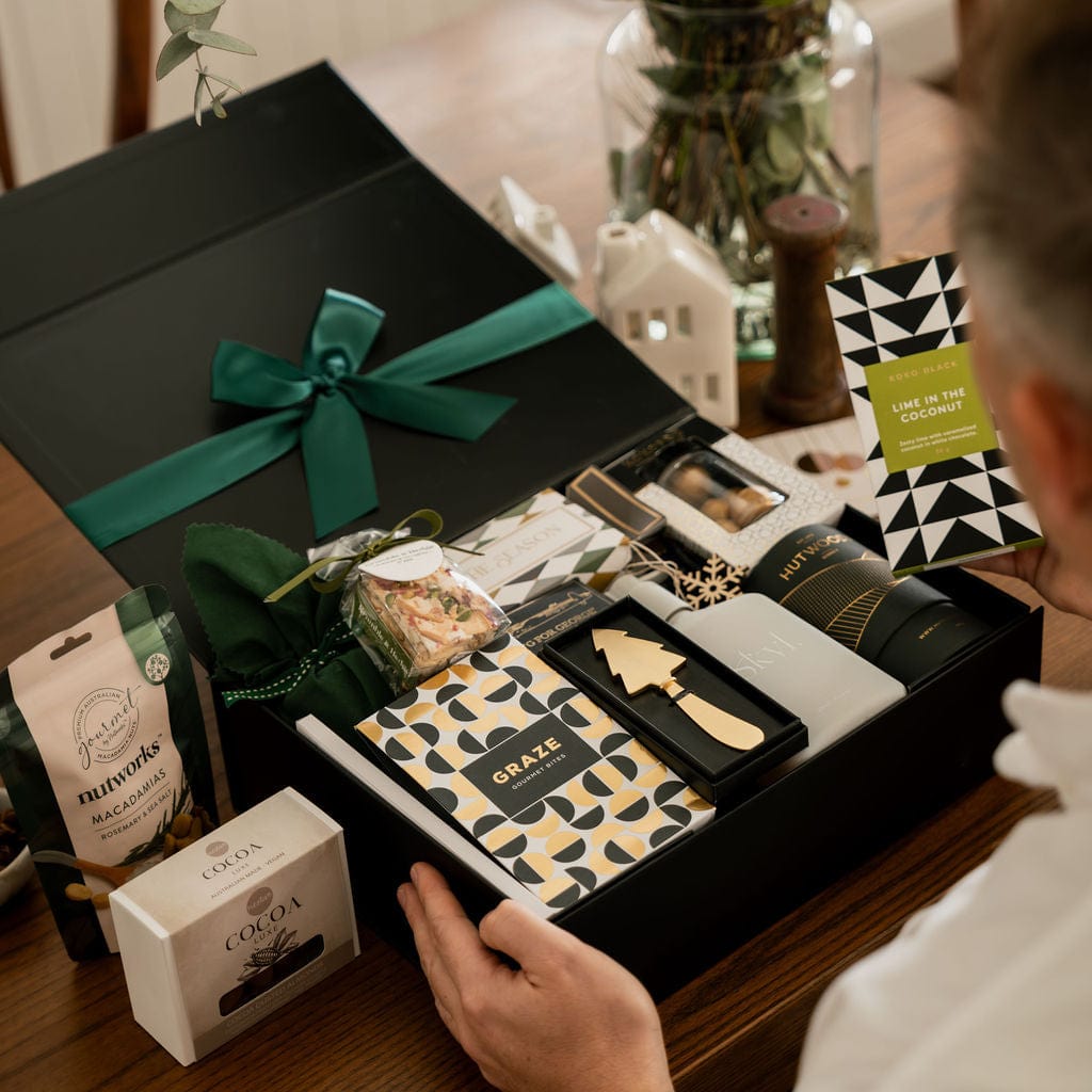 man holding open gift box to show contents 