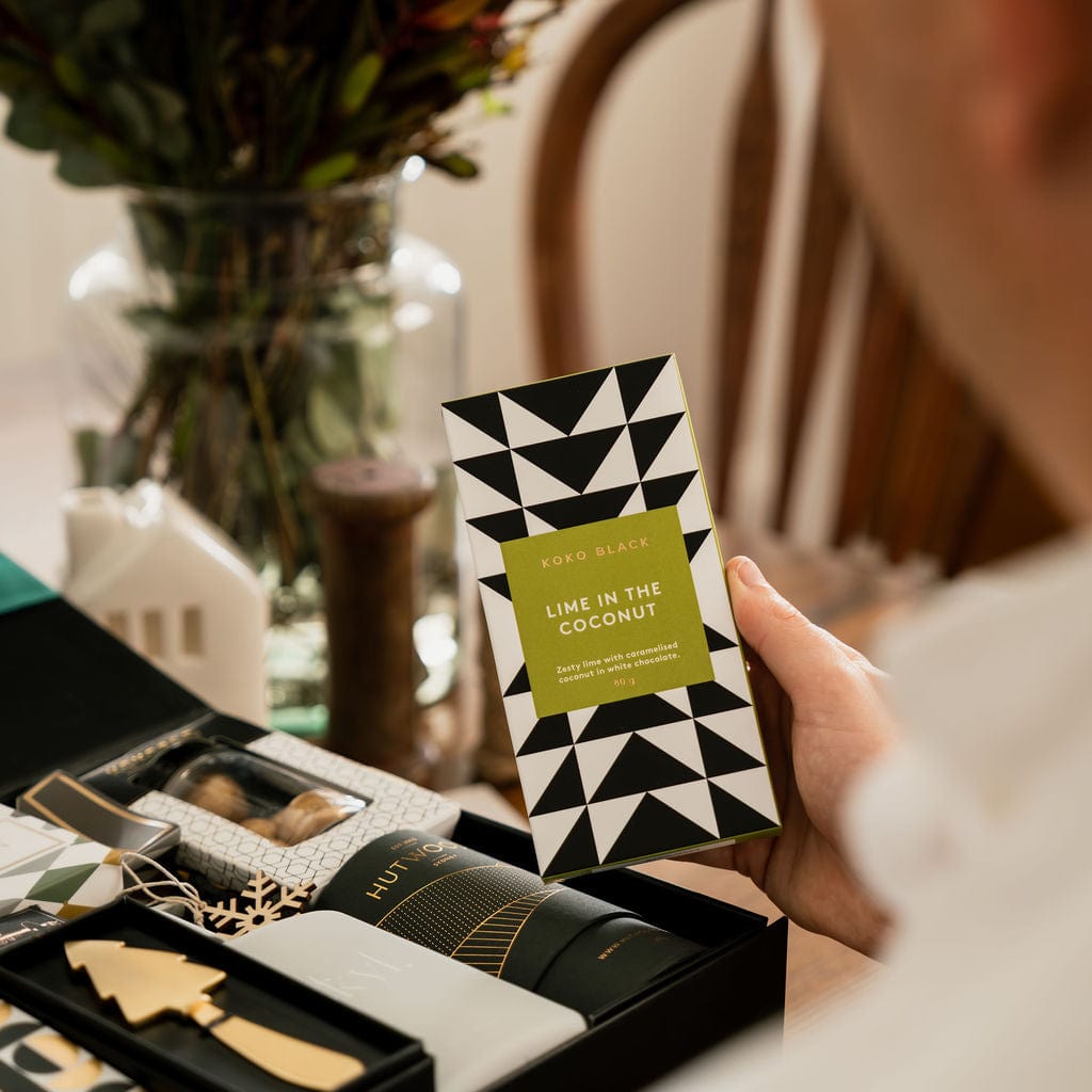 man holding lime coconut chocolate bar with green and black packaging 