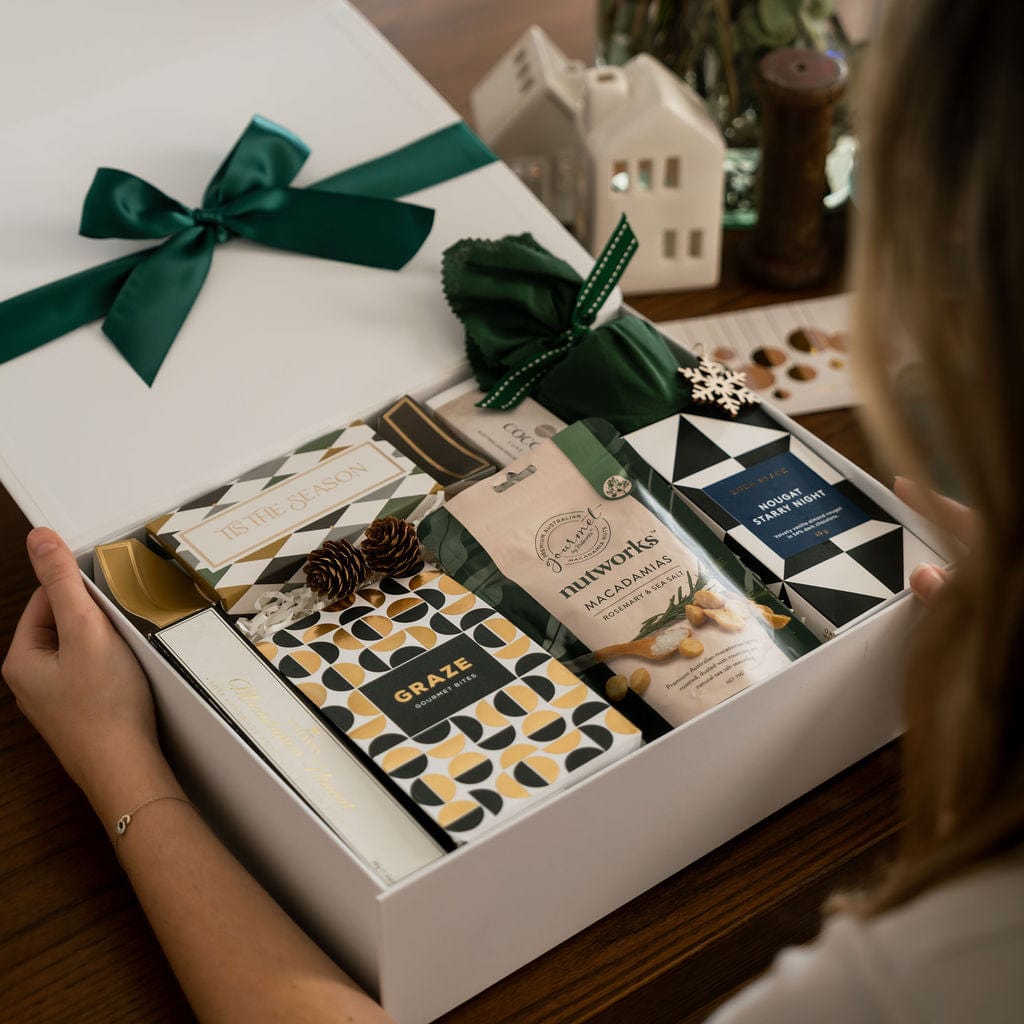 woman opening gift box to show contents, chocolate, nuts, pudding, christmas bon bon 