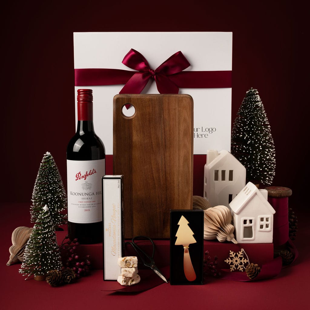 red themed christmas gift with chopping board, red wine, gold tree cheese knife and nougat 