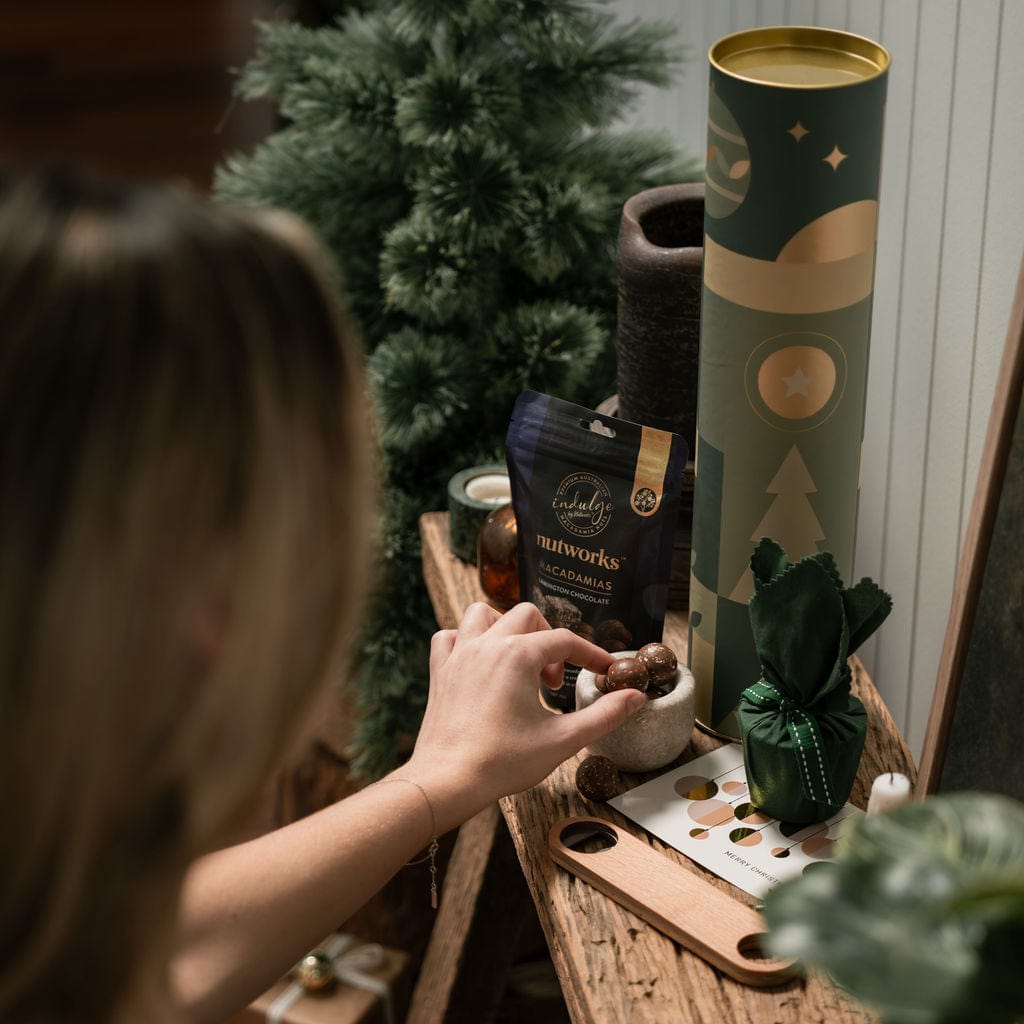 woman reaching for chocolate in christmas cylinder gift