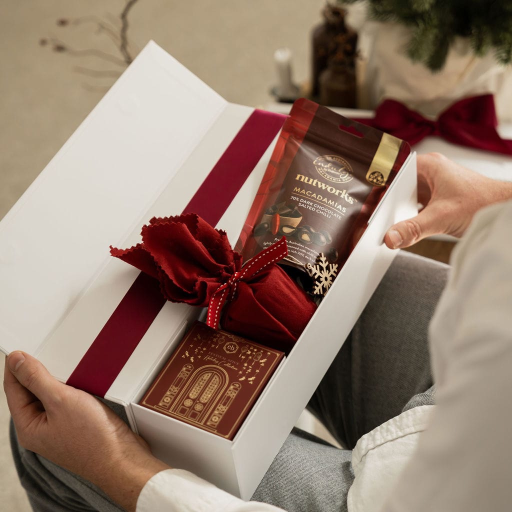 man opening red christmas gift with ribbon 