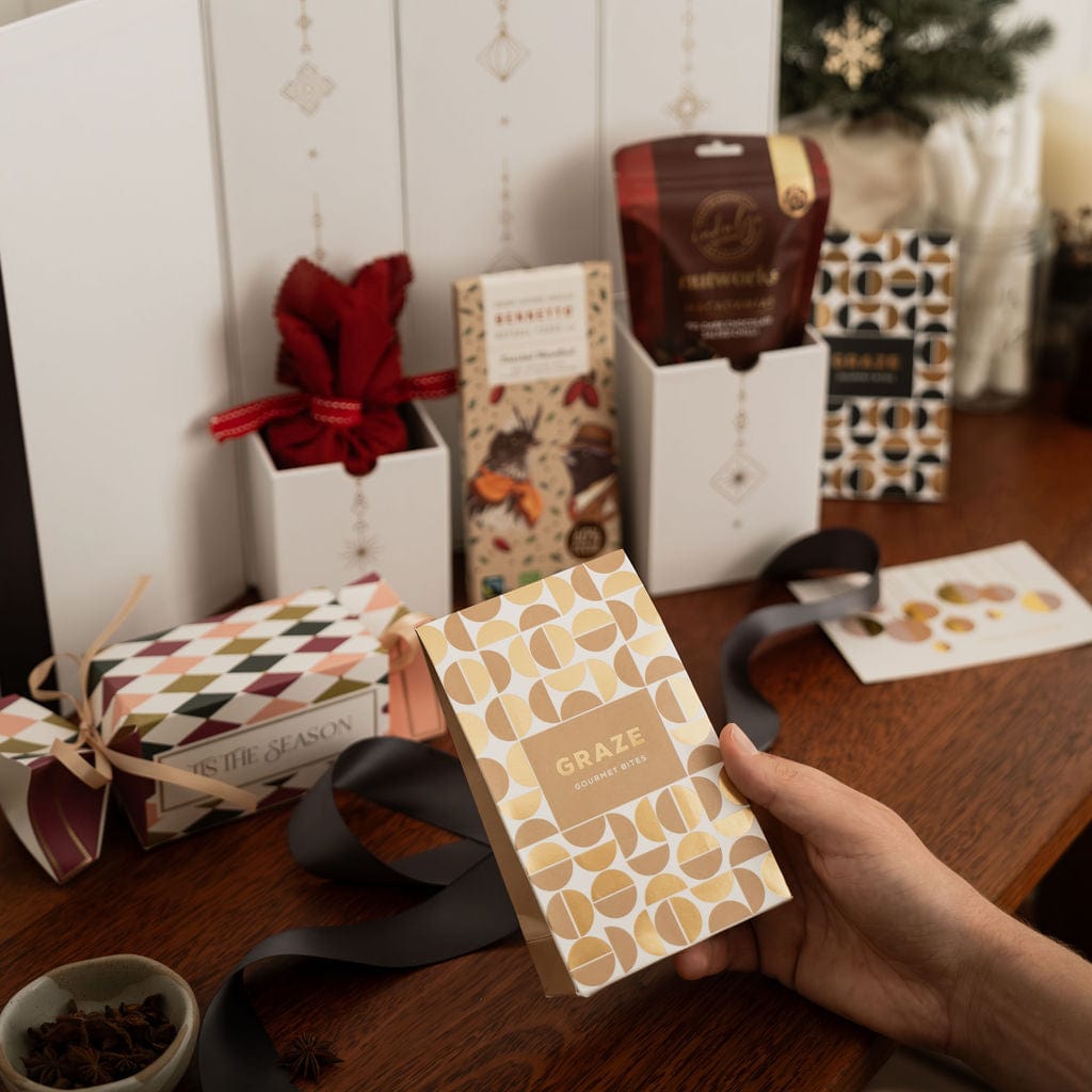 hand holding gold packaged nuts in front of advent gift with content showing