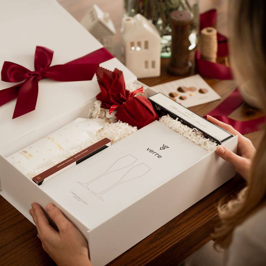 woman opening gift box to show contents with red ribbon 