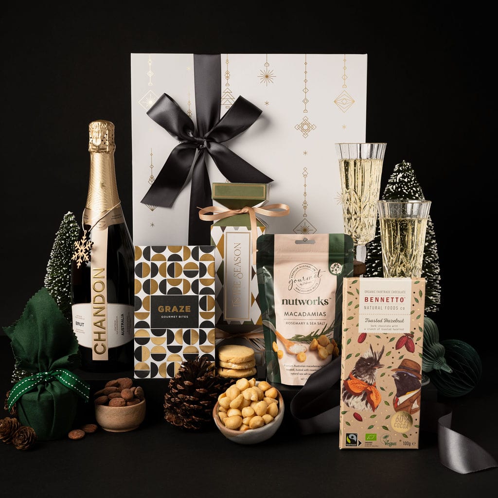 black and gold themed advent gift box with black ribbon showing chandon, champagne glasses and chocolate on display